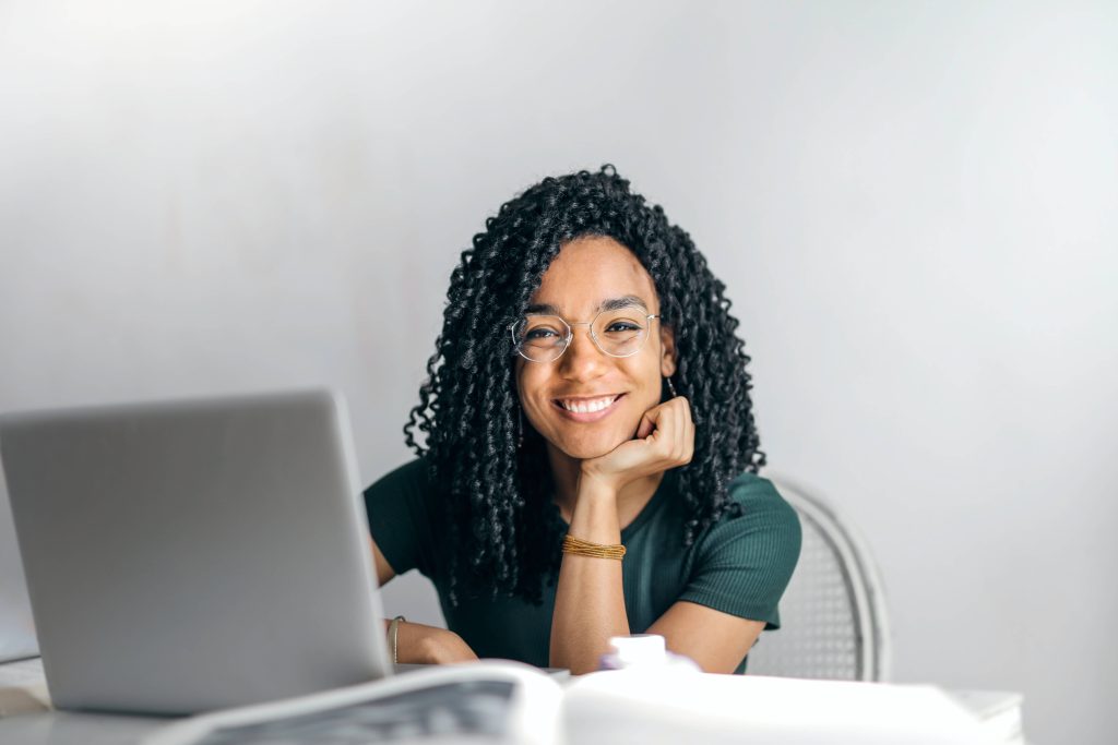 Woman smiling in front of computer | Tips for empowering women in the workplace